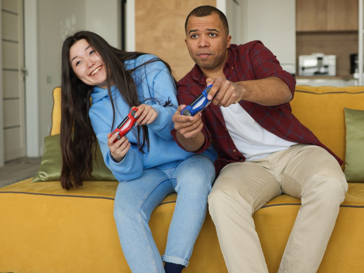 Two tenants playing video games on the sofa of a rental flat